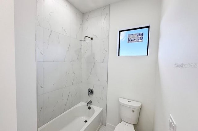 bathroom with toilet and tiled shower / bath