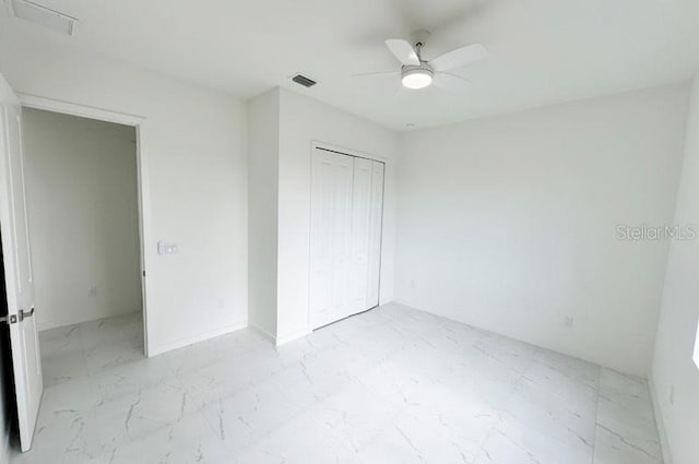 unfurnished bedroom featuring ceiling fan and a closet