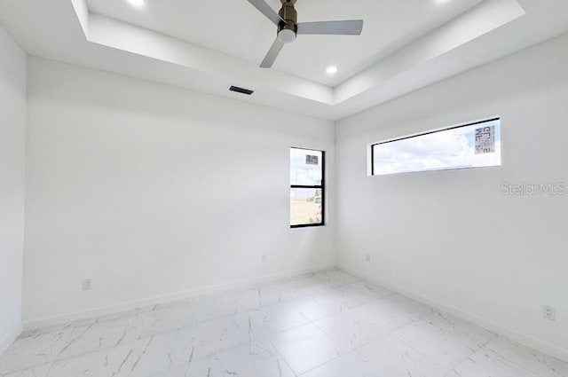 unfurnished room featuring ceiling fan and a tray ceiling