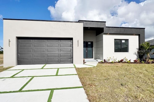 contemporary house featuring a front yard and a garage