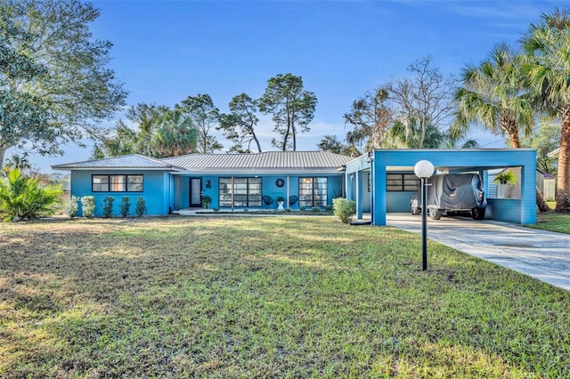 view of front facade with metal roof, a front lawn, a carport, and driveway