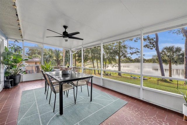 unfurnished sunroom with ceiling fan and a water view