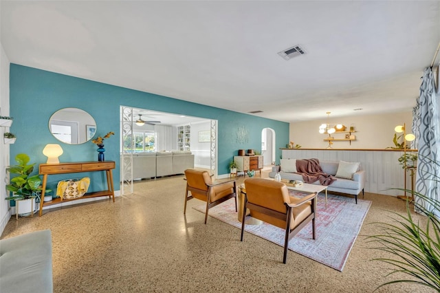 living room featuring ceiling fan with notable chandelier