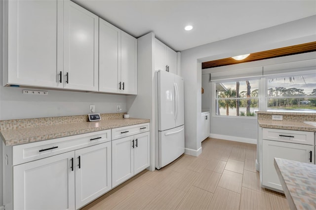 kitchen featuring white cabinetry and white fridge