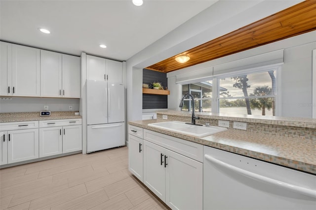 kitchen with sink, white appliances, and white cabinets