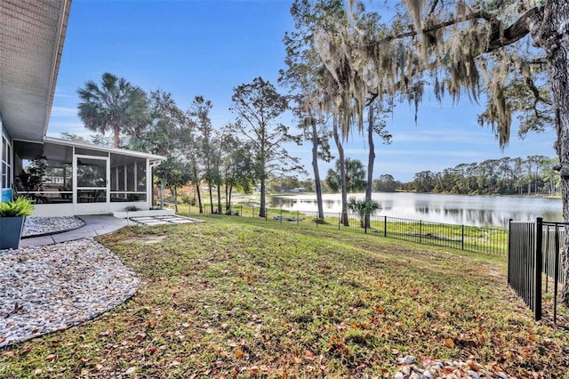 view of yard with a sunroom and a water view