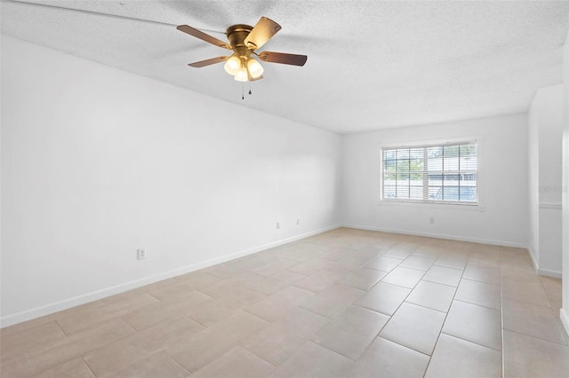 tiled empty room with ceiling fan and a textured ceiling