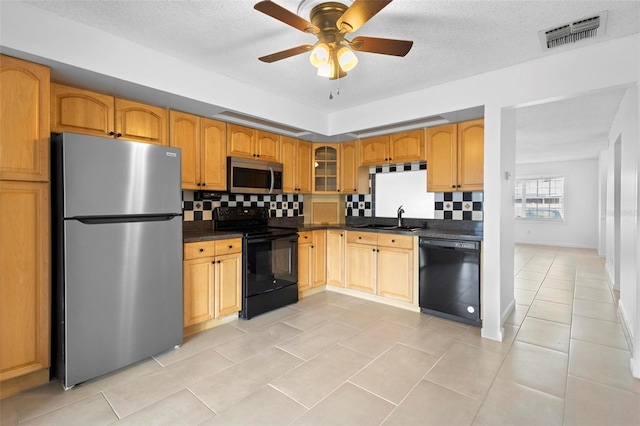 kitchen featuring black appliances, light tile patterned flooring, sink, and tasteful backsplash