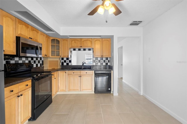 kitchen with tasteful backsplash, a textured ceiling, sink, black appliances, and light tile patterned flooring