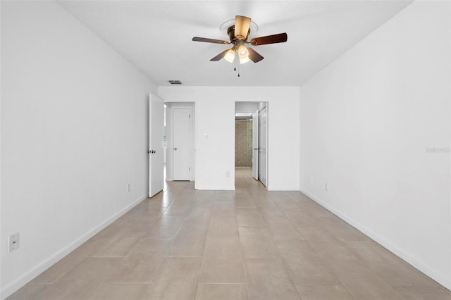 unfurnished room with ceiling fan, light tile patterned floors, and a textured ceiling