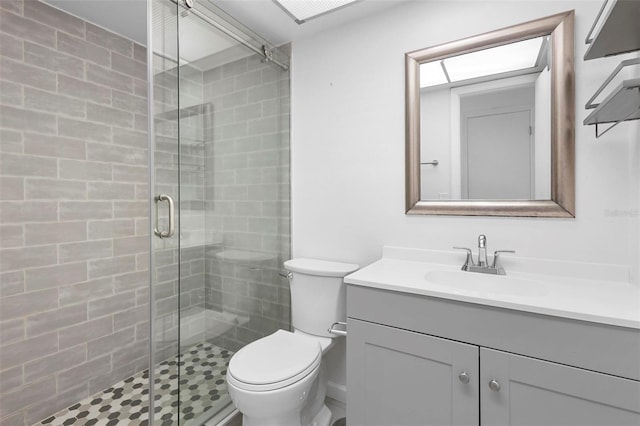 bathroom with vanity, toilet, and a shower with door