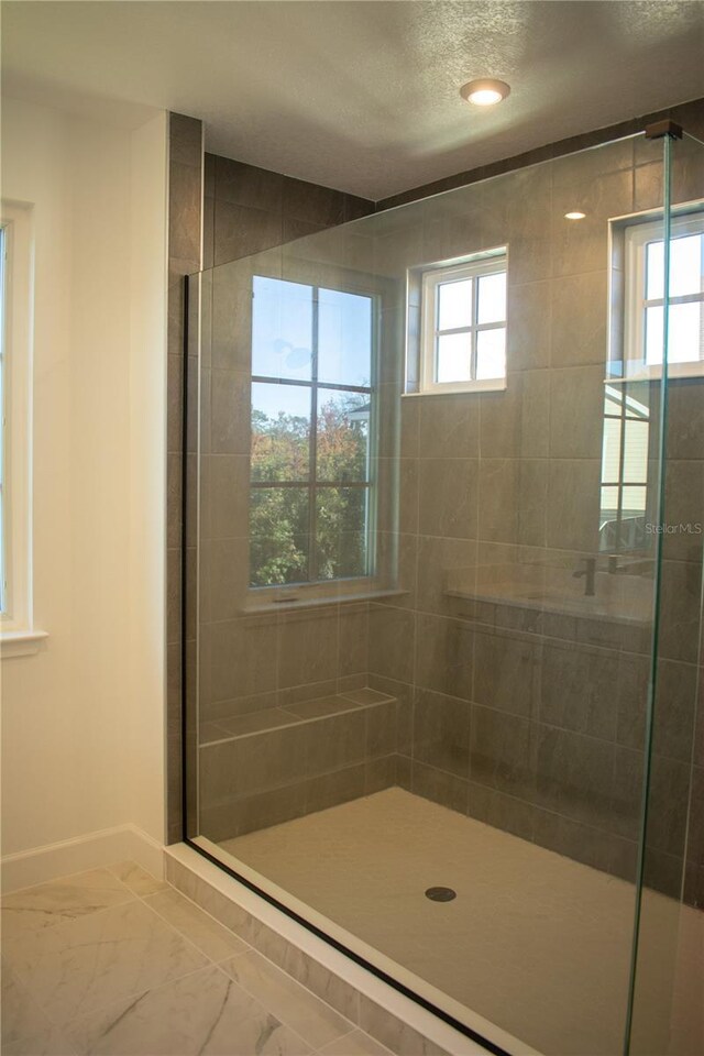 bathroom featuring tiled shower and a healthy amount of sunlight