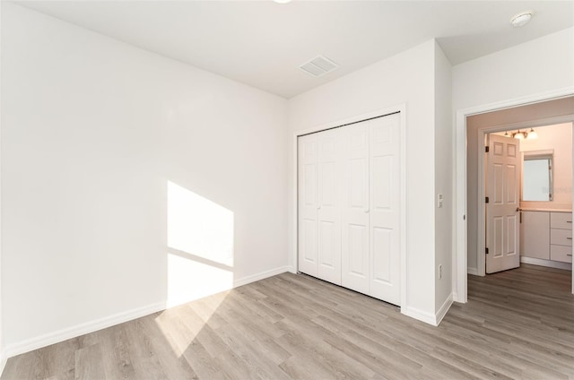 unfurnished bedroom featuring a closet and light wood-type flooring