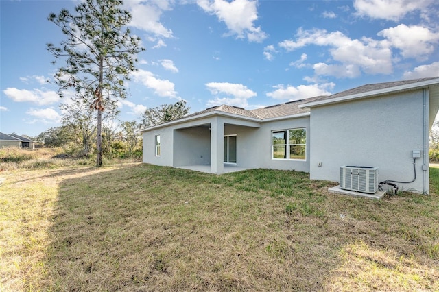 rear view of house featuring central air condition unit, a yard, and a patio