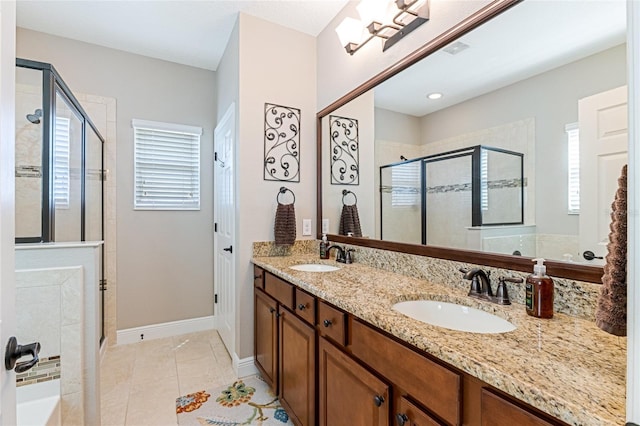 full bath featuring double vanity, a stall shower, a sink, and tile patterned floors