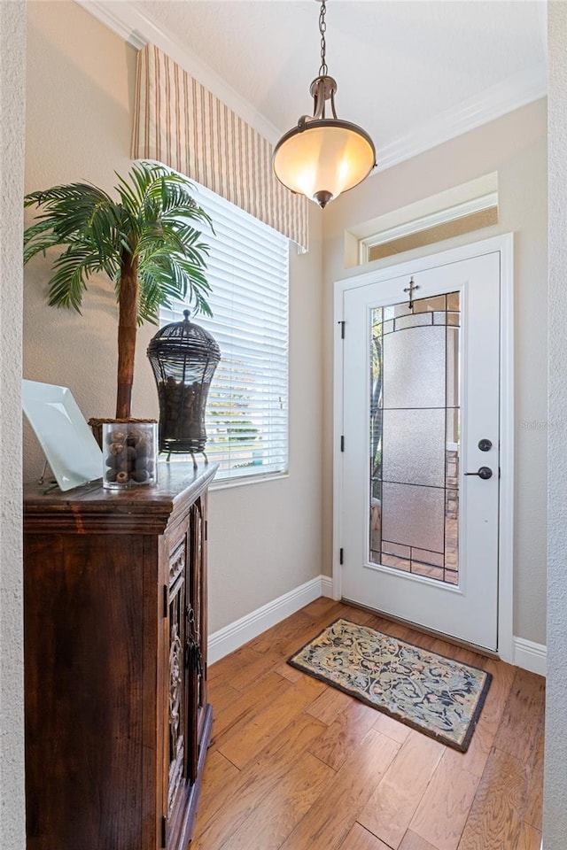 foyer entrance with light wood-type flooring and crown molding