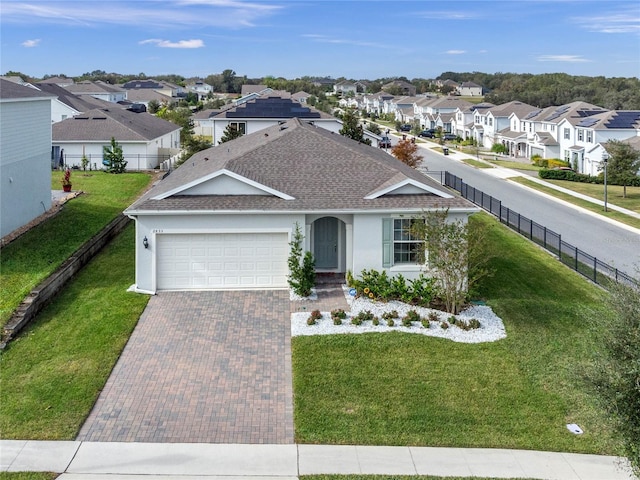 ranch-style house featuring a garage and a front lawn