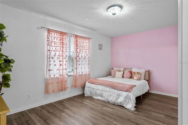 bedroom featuring wood-type flooring and a textured ceiling