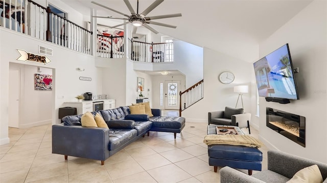 2377 Victoria Dr, Davenport, FL 33837 - living room with light tile patterned floors, stairway, a ceiling fan, a towering ceiling, and beverage cooler