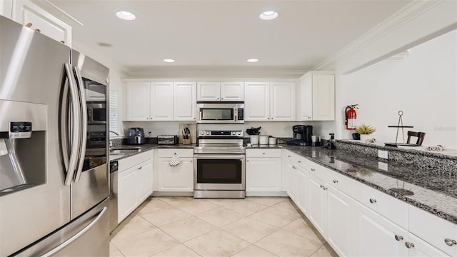 2377 Victoria Dr, Davenport, FL 33837 - kitchen with appliances with stainless steel finishes, crown molding, white cabinetry, dark stone counters, and light tile patterned floors