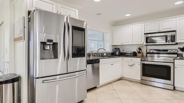 2377 Victoria Dr, Davenport, FL 33837 - kitchen featuring stainless steel appliances, white cabinets, light tile patterned floors, ornamental molding, and recessed lighting