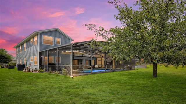 2377 Victoria Dr, Davenport, FL 33837 - back of property at dusk featuring a lawn, a patio, an outdoor pool, and glass enclosure