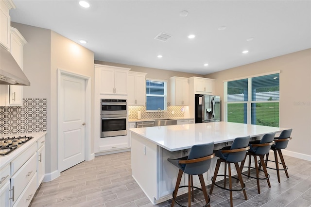 kitchen featuring a kitchen breakfast bar, decorative backsplash, a center island, and stainless steel appliances