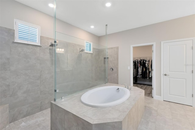 bathroom featuring tile patterned flooring and shower with separate bathtub