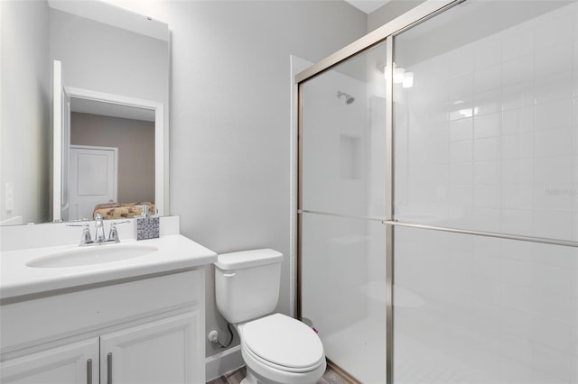 bathroom featuring toilet, vanity, and walk in shower