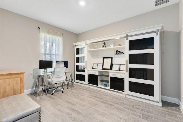 home office with light hardwood / wood-style floors