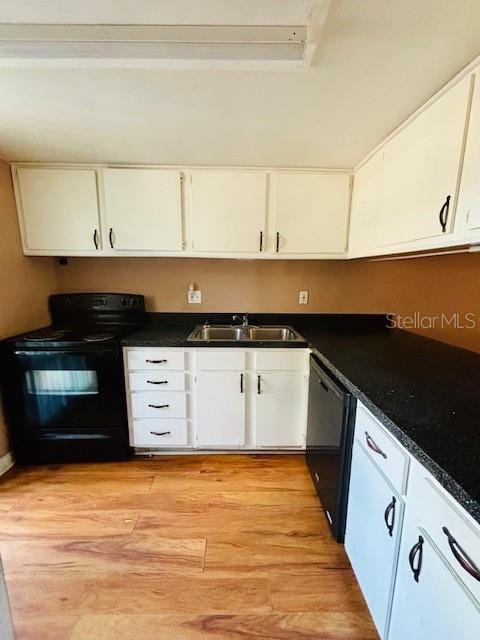 kitchen with black appliances, white cabinets, and sink