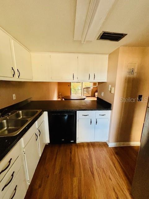 kitchen with dishwasher, white cabinets, hardwood / wood-style floors, and sink