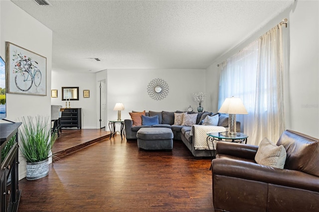 living room with dark hardwood / wood-style floors and a textured ceiling