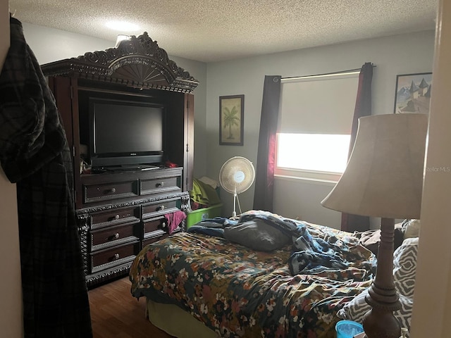 bedroom featuring dark hardwood / wood-style floors and a textured ceiling