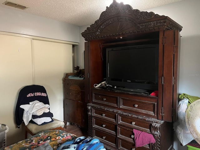 bedroom with a textured ceiling and hardwood / wood-style flooring