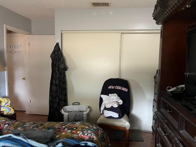 bedroom featuring a closet, hardwood / wood-style floors, and a textured ceiling