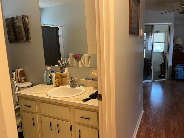 bathroom with vanity, ceiling fan, toilet, a textured ceiling, and wood-type flooring