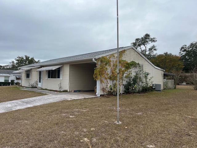 view of front of house with a front yard, central AC unit, and a carport