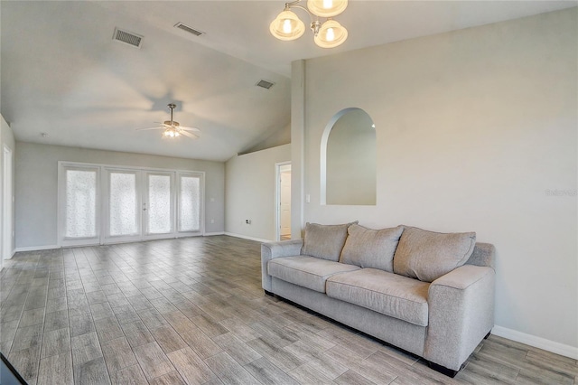 living room with vaulted ceiling and ceiling fan with notable chandelier