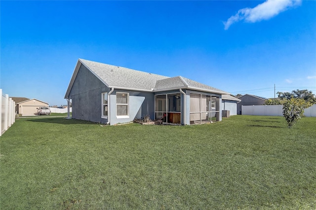 back of house featuring central AC unit, a lawn, and a sunroom