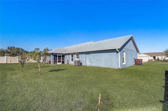 back of property featuring a yard, cooling unit, and a garage