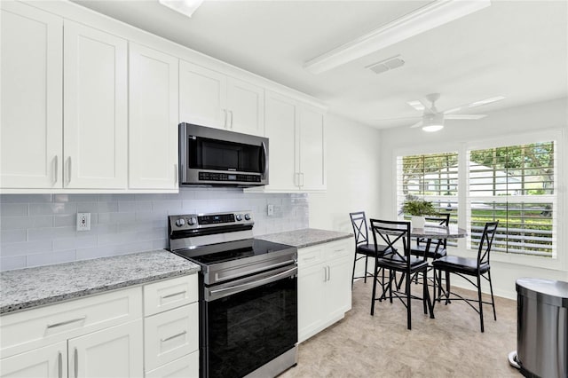 kitchen with ceiling fan, light stone countertops, appliances with stainless steel finishes, tasteful backsplash, and white cabinetry