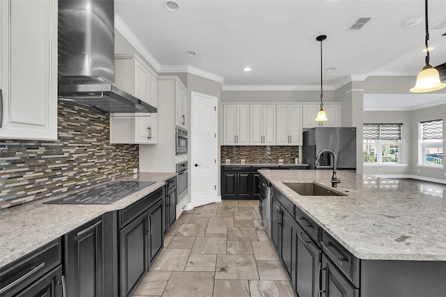 kitchen with sink, stainless steel appliances, wall chimney range hood, decorative light fixtures, and white cabinets