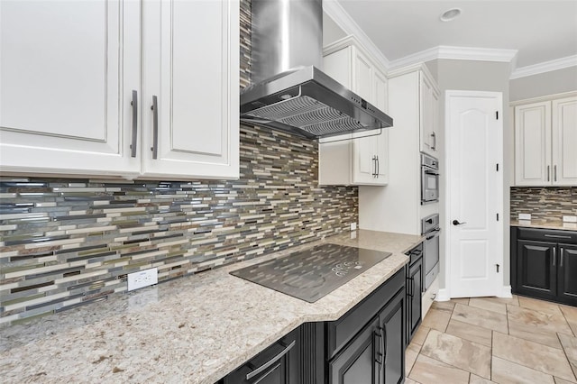 kitchen featuring decorative backsplash, black electric stovetop, wall chimney range hood, white cabinetry, and oven