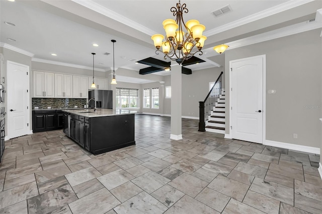 kitchen featuring decorative backsplash, crown molding, decorative light fixtures, white cabinets, and an island with sink