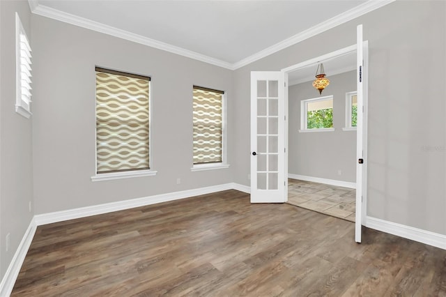 empty room featuring french doors, dark hardwood / wood-style flooring, and crown molding