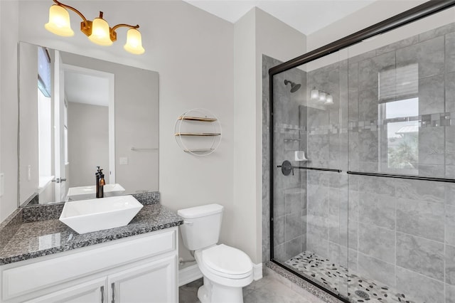 bathroom with vanity, toilet, and a shower with door