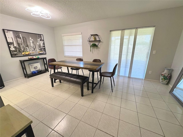 dining room featuring light tile patterned floors and a textured ceiling