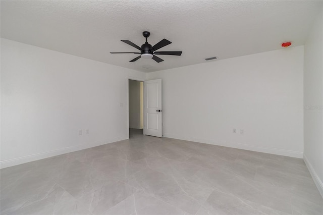 unfurnished room with ceiling fan and a textured ceiling