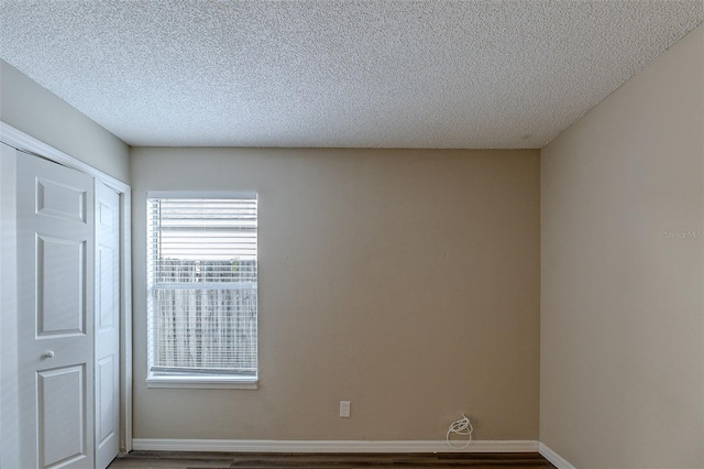 interior space with wood-type flooring, a textured ceiling, and a closet